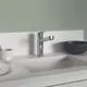 Küchenarmatur von Ideal Standard mit einem schlanken, verchromten Design und einem seitlichen Rohrauslauf; montiert auf einer hellen Arbeitsplatte neben Schalen und Geschirr.